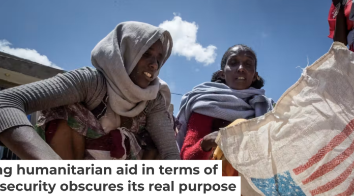 A woman scoops up portions of wheat to be allocated to each waiting family after it was distributed in the Tigray region of northern Ethiopia in 2021. AP Photo/Ben Curtis